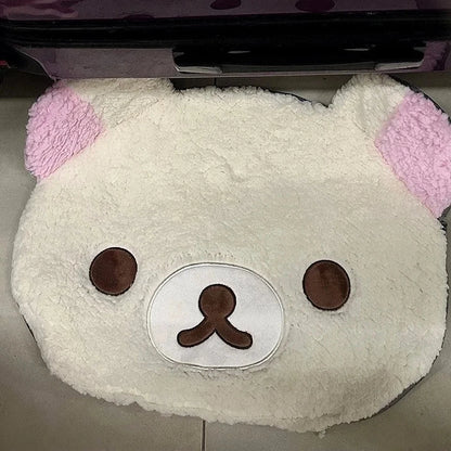 Plush toy with pink ears and a white face on a gray surface