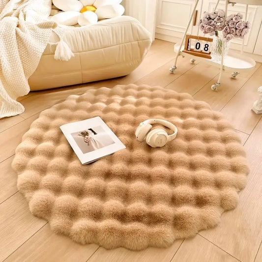 Round textured rug on a wooden floor with a book and headphones on top, in a cozy room setting.