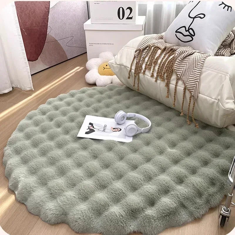 Round green rug on a wooden floor with a pillow and headphones on top