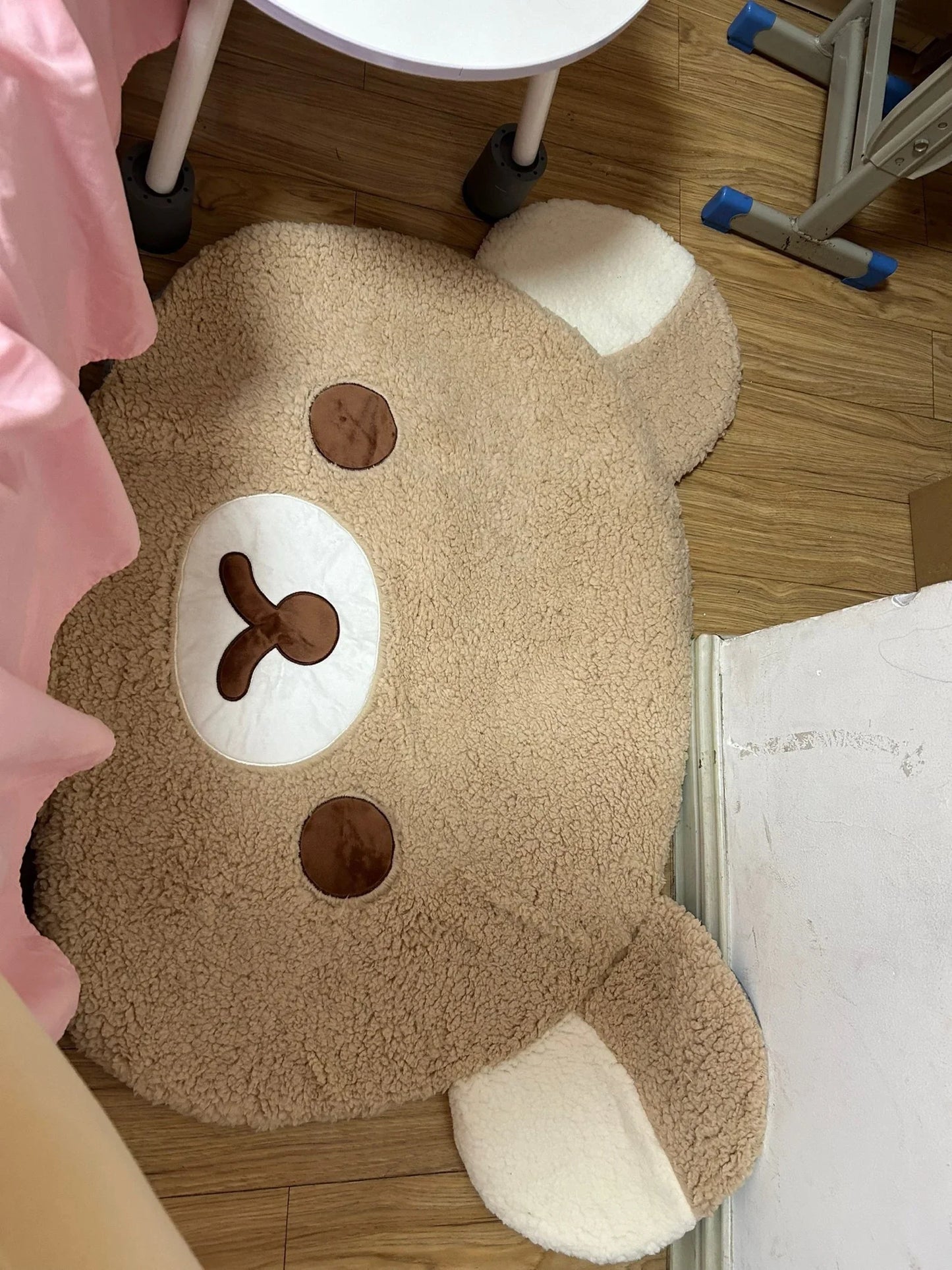 Brown bear-shaped rug on a wooden floor