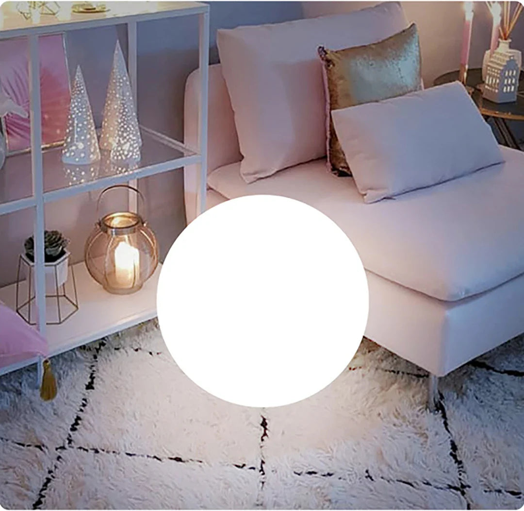 Living room with a white sofa, decorative pillows, and a shelf with small decorative items.