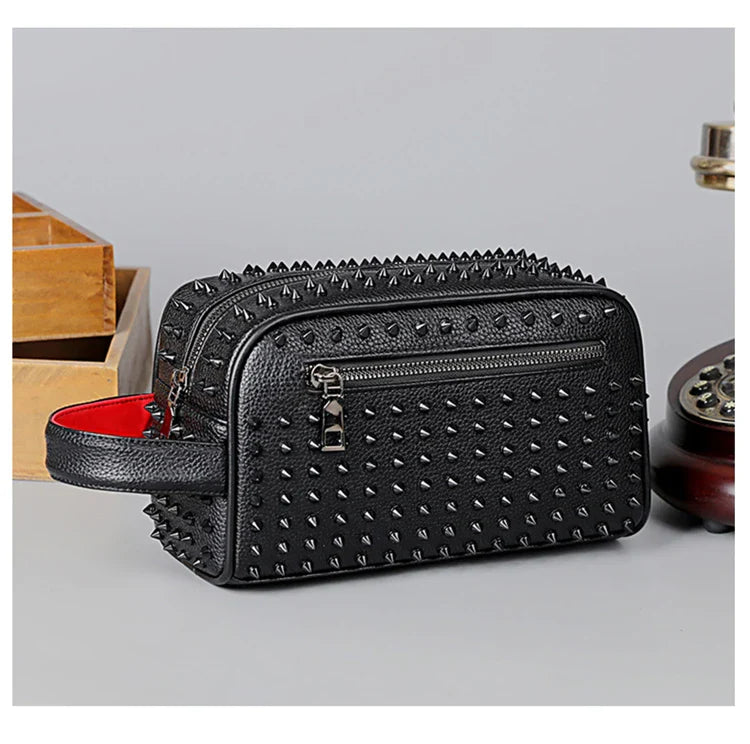 Black studded cosmetic bag with a red interior on a light gray background