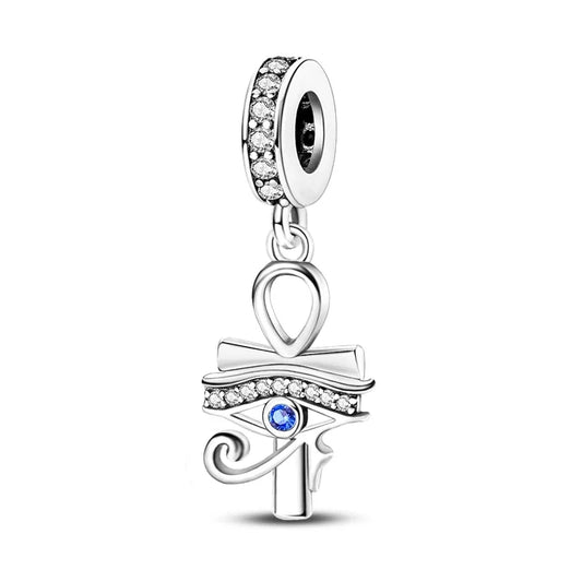 Silver charm with eye design and blue gem on a white background