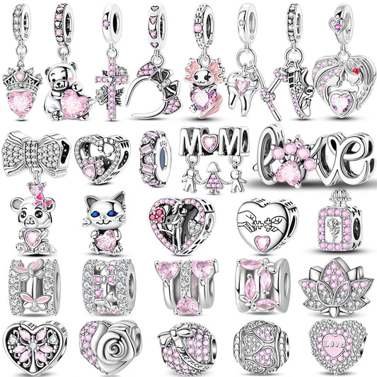 Collection of various silver and pink charms on a white background. pandora style