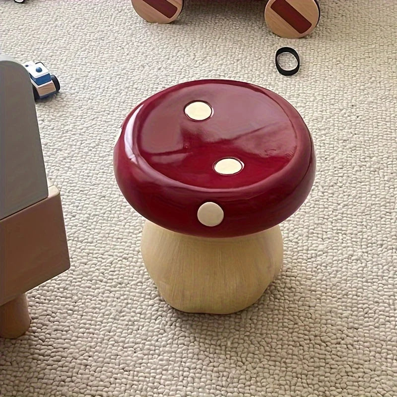 Mushroom-shaped stool with red cap and beige stem on a carpeted floor.