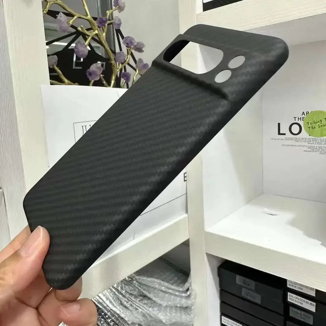 Black phone case held by a hand with a blurred indoor background