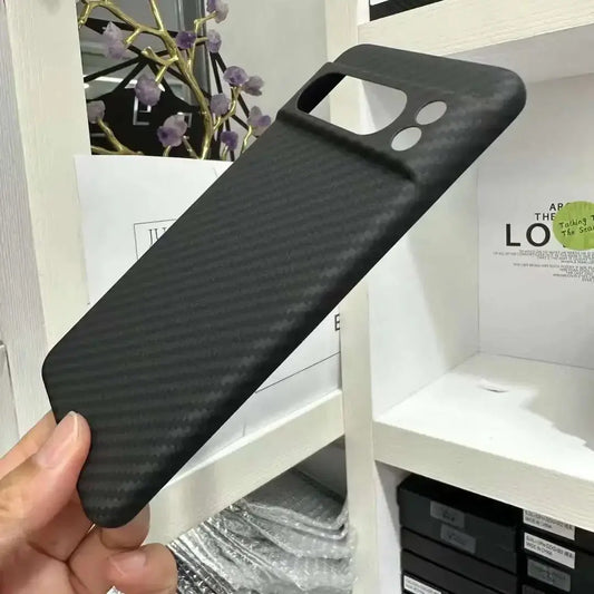 Black phone case held by a hand with a blurred indoor background