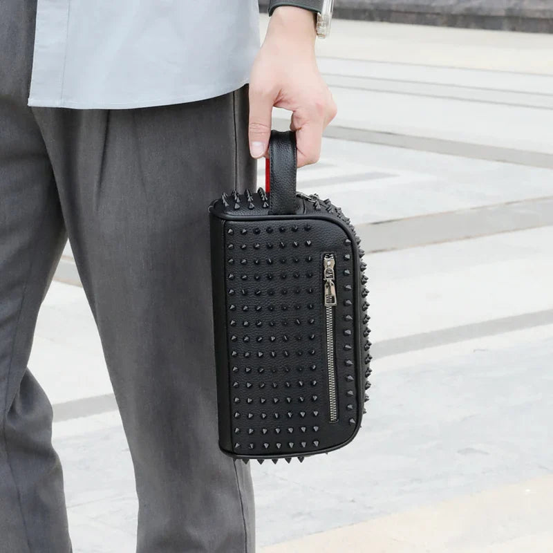 Person holding a black studded suitcase with a blurred background