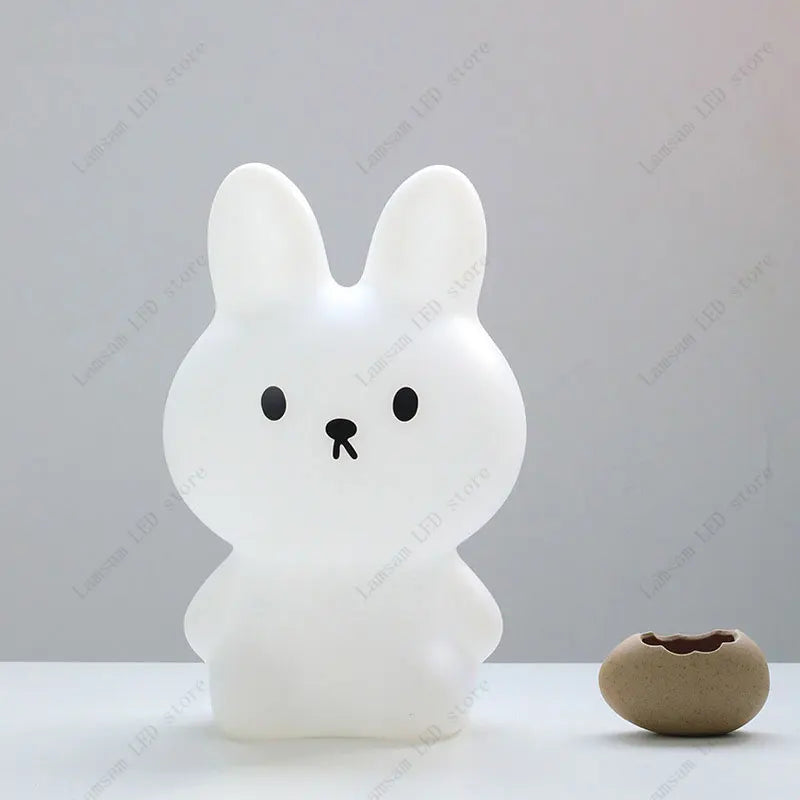 White rabbit-shaped night light on a white surface with a neutral background