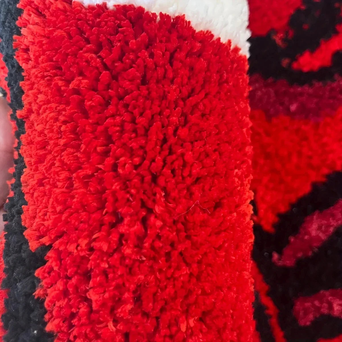 Close-up of a textured red fabric with black and white accents