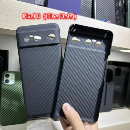 Two phone cases with 'Pixel 8 (Fine Hole)' text held by a hand against a blurred background.