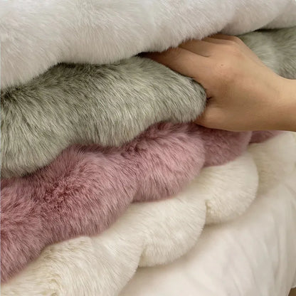 Stack of fluffy textured rugs in various colors with a hand touching them.