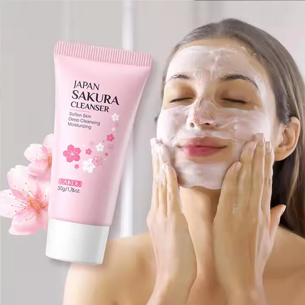 Woman applying facial cleanser with a pink 'Japan Sakura Cleanser' tube and cherry blossom flower in the background.