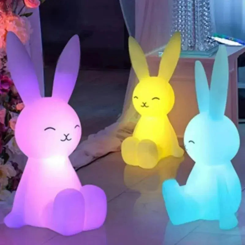 Three colorful rabbit-shaped lights on a floor with a blurred background