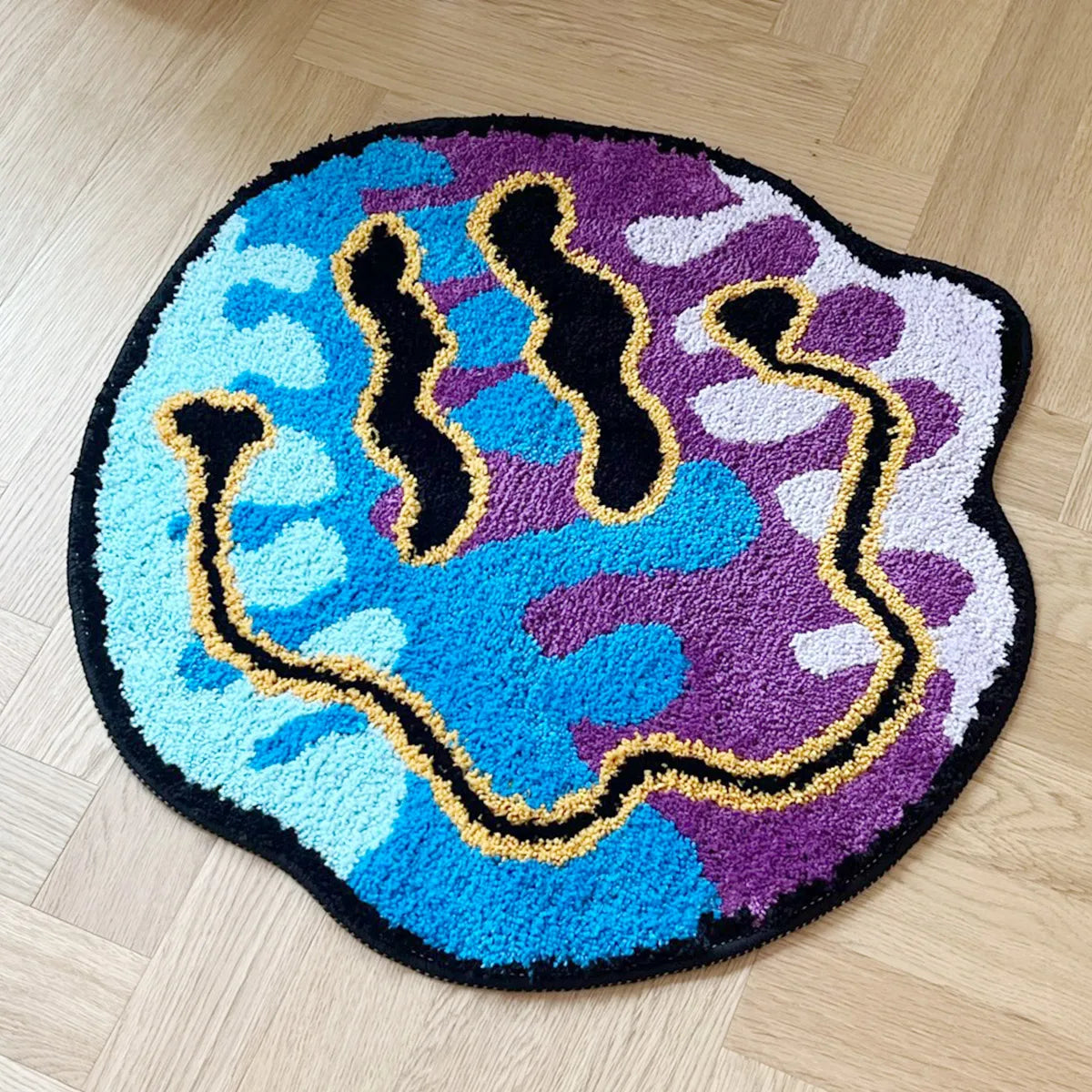 Round rug with colorful abstract design on a wooden floor