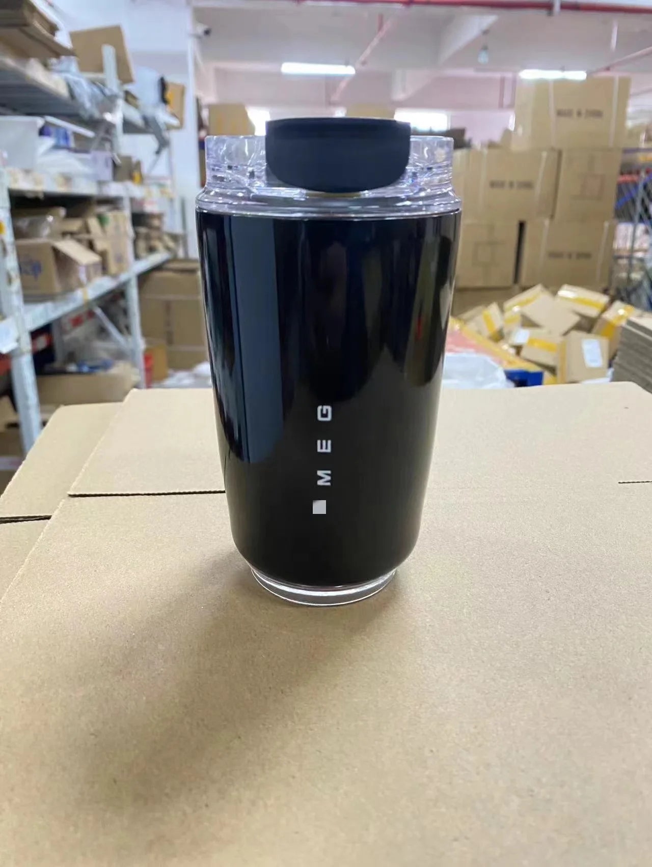 SMEG Black container with 'SMEG' branding on a cardboard surface in a warehouse setting