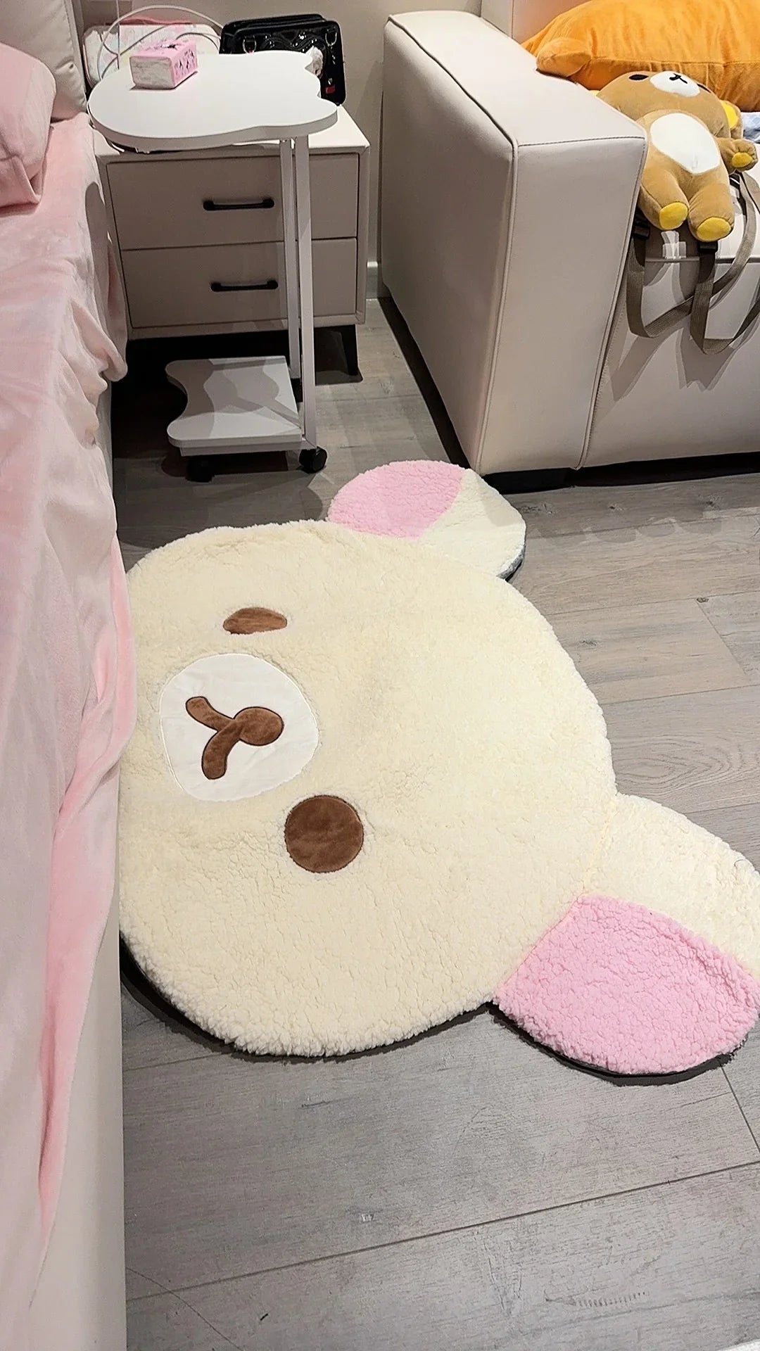 Cute animal-shaped rug on a wooden floor with a bed and furniture in the background