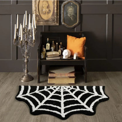 Room interior with spider web rug, candelabra, and dark wall with framed pictures.