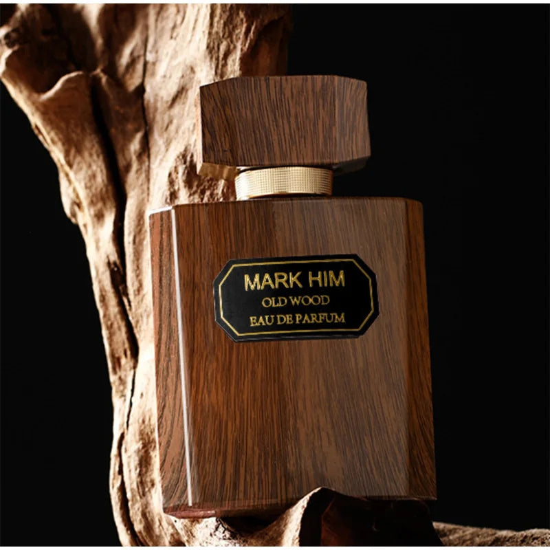 Wooden perfume bottle labeled 'Mark Him Old Wood' against a dark background