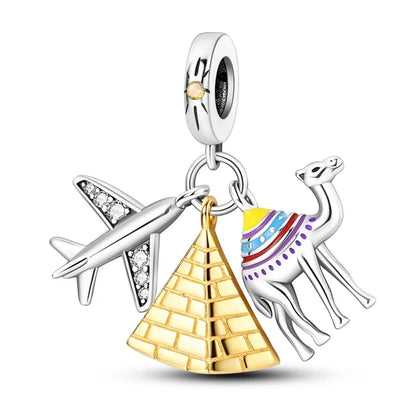 Jewelry charm with airplane, pyramid, and camel on a white background