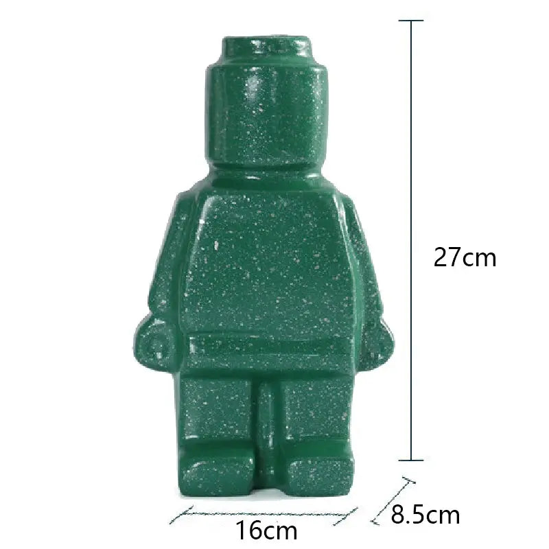 Two Lego Man Vases, one black and one white, designed to look like figures with a decorative plant in each.