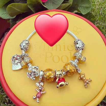 Bracelet with charms on a yellow heart-shaped pad with 'Pine & Pool' branding.