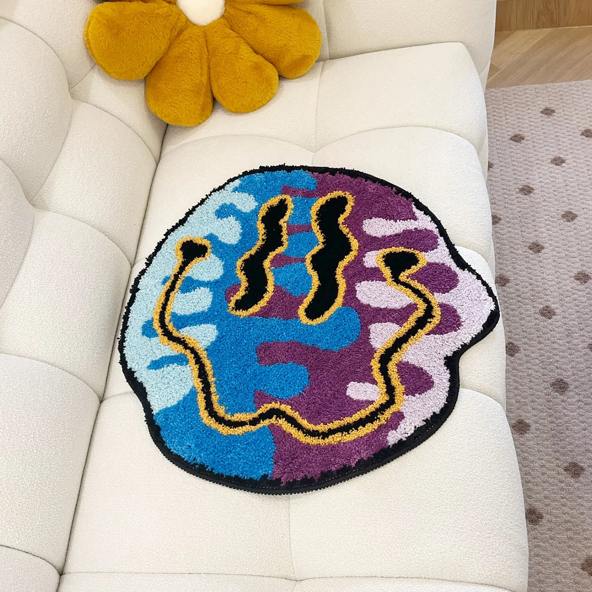 Colorful abstract rug on a white sofa with a yellow flower decoration.