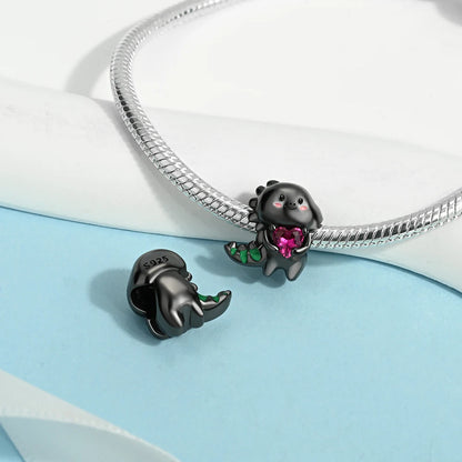 Black animal-shaped charm with a pink gem on a snake chain against a light blue and white background. pandora style charm pendant