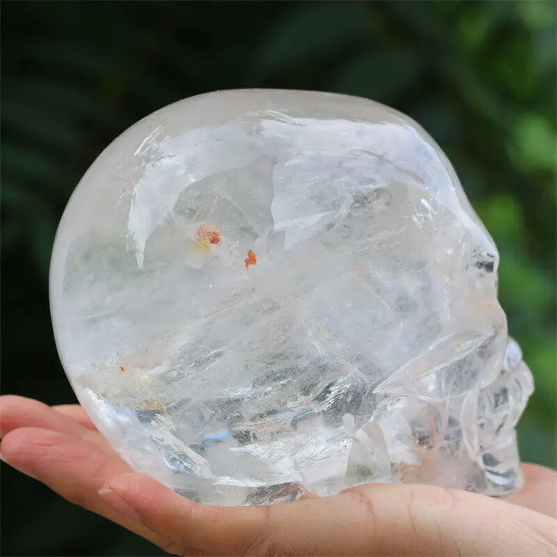Clear crystal ball held in a hand with a blurred green background