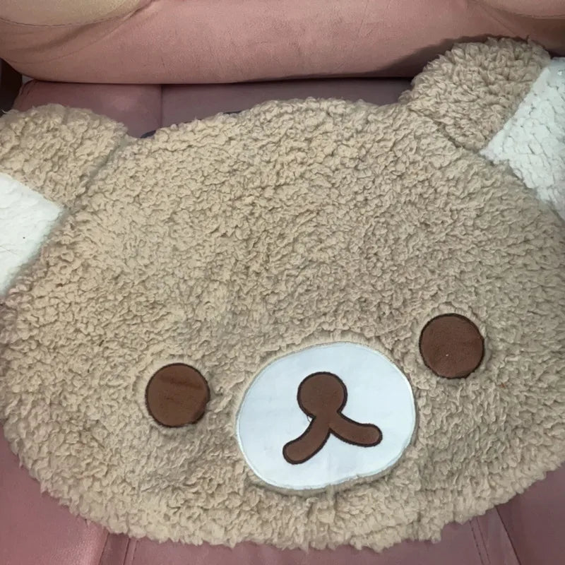 Plush toy with a bear face design on a pink surface