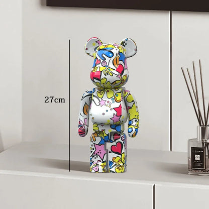 Colorful bear-shaped figure on a white surface with a measurement label, next to a diffuser. be@rbrick collectable