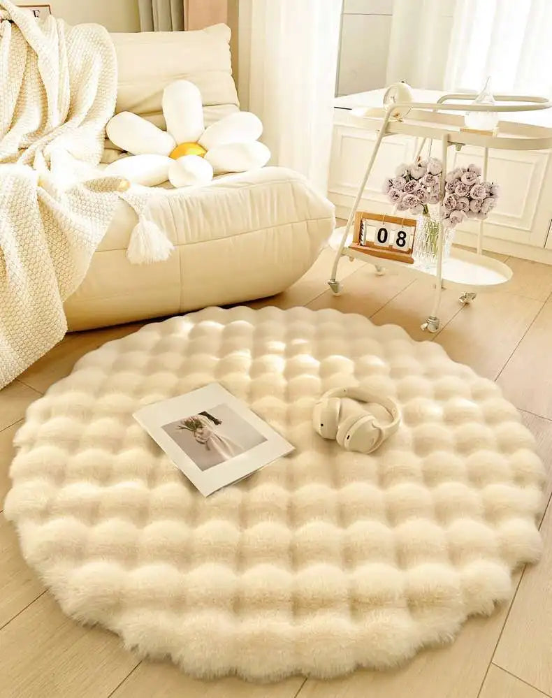 Round white fluffy rug in a room with a chair, teddy bear, and decorative items.