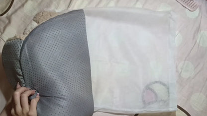 Gray pillow with a textured pattern on a light-colored surface