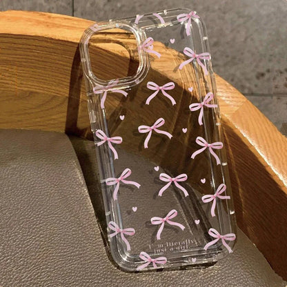 Clear phone case with pink bows on a wooden surface