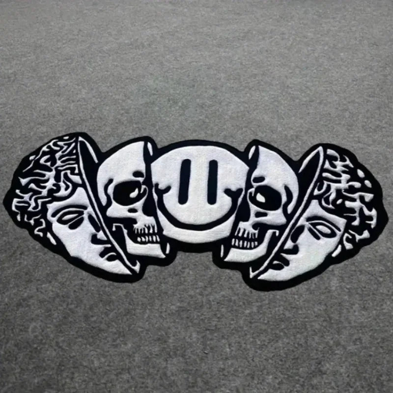 Silver skull and leaf design on a gray background