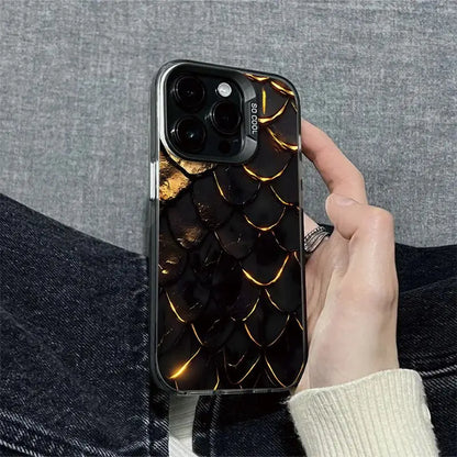Phone case with dragon scale design held by a person against a gray background