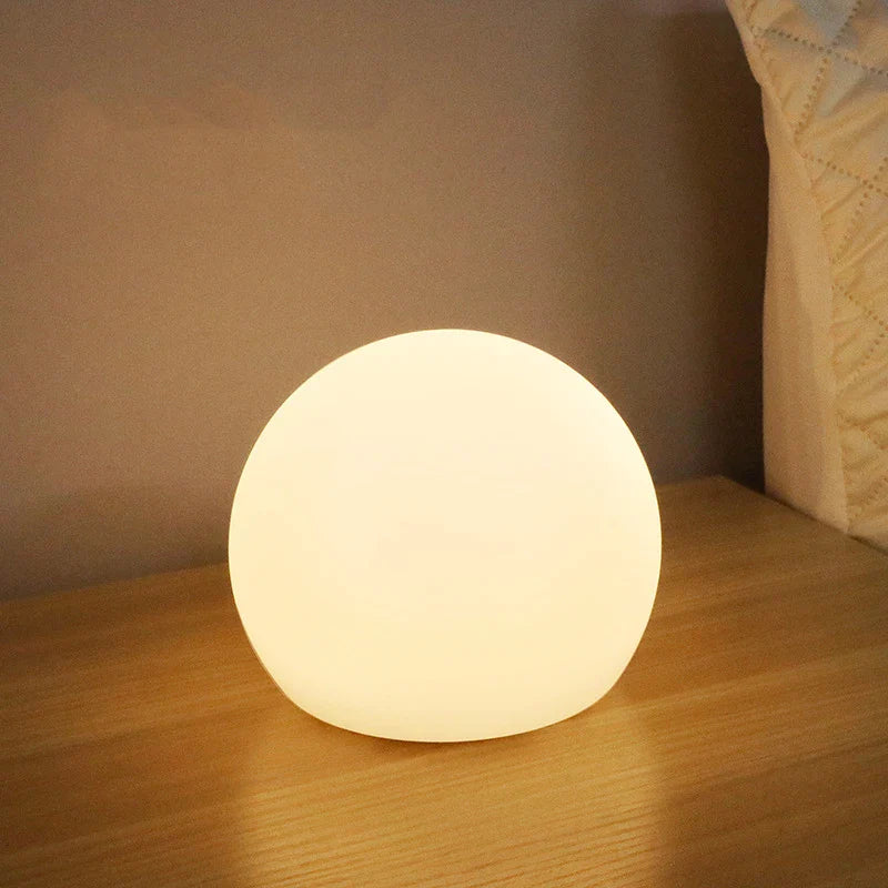 Round white lamp on a wooden surface with a neutral background