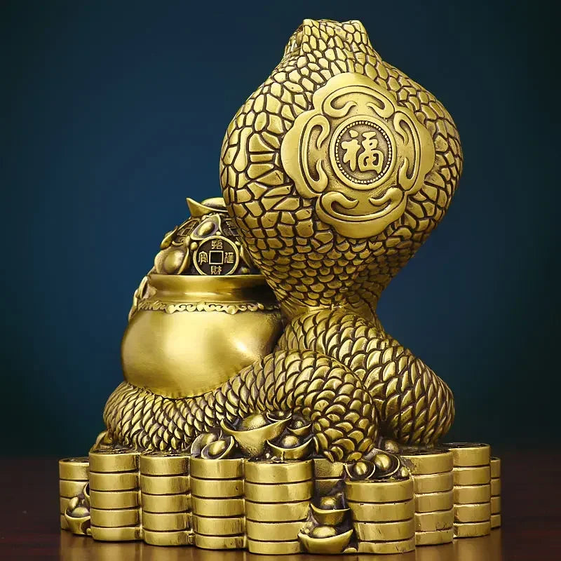 A bronze colored metal ornament in the shape of a snake coiled around a pot with Chinese characters inscribed, representing the Twelve Zodiac Snakes theme.