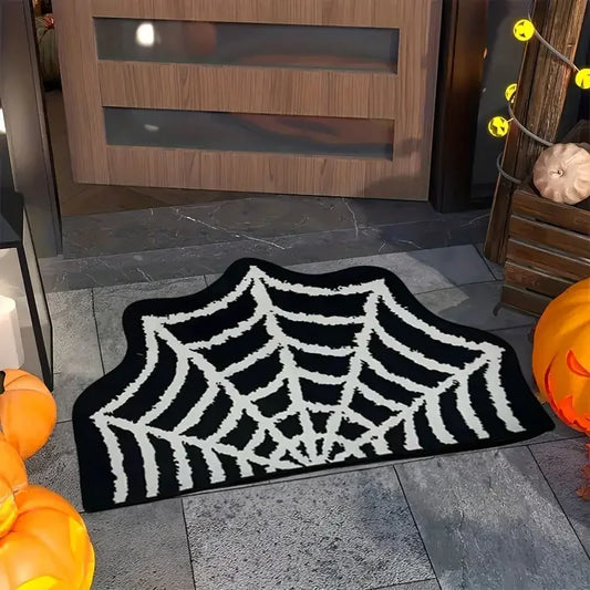 Spider web doormat on a stone floor with pumpkins and a wooden door in the background