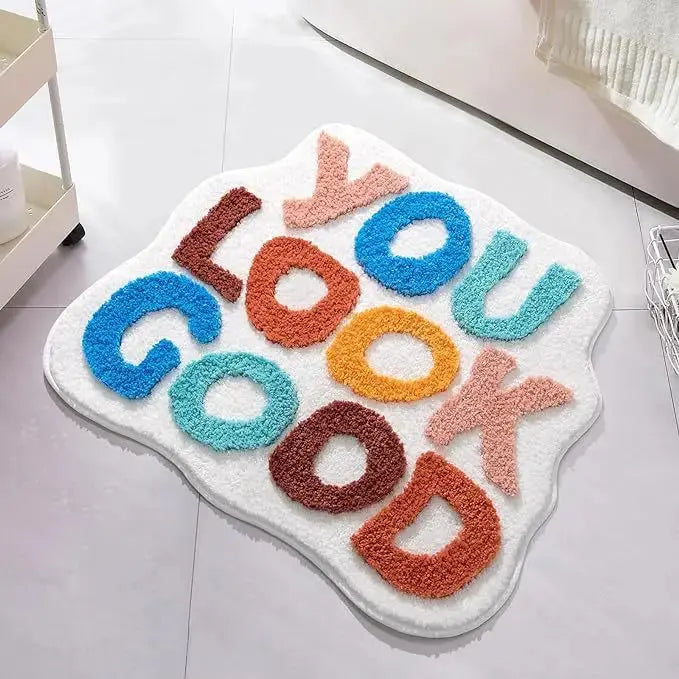 Colorful doormat with 'YOU LOOK GOOD' text on a white floor. bath mat