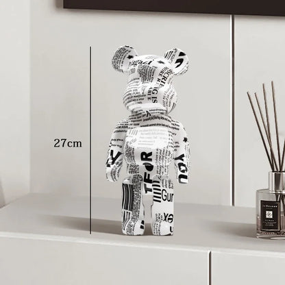 Black and white bear figure with text on a shelf next to a diffuser be@rbrick collectable