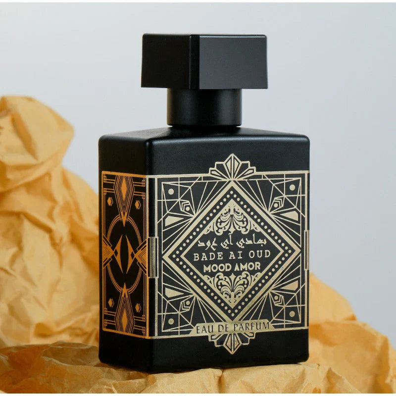 Black perfume bottle with gold design on a textured beige background