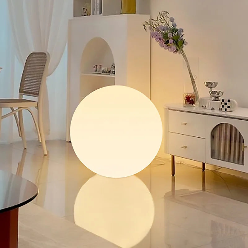 Glowing spherical lamp on a reflective floor in a modern room.