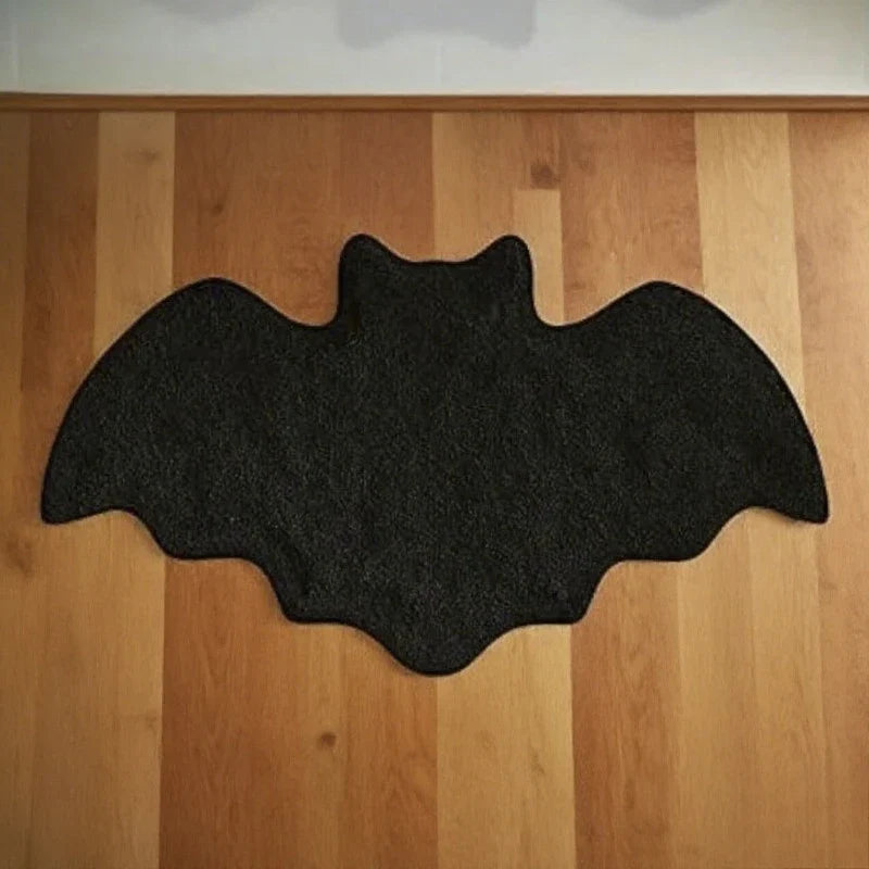Black bat-shaped mat on a wooden floor