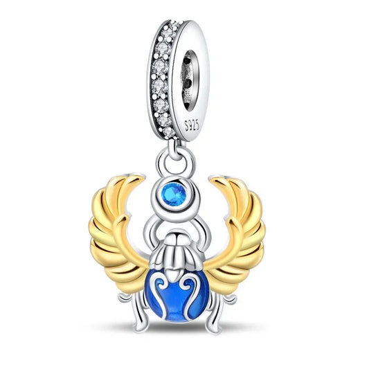 Beetle Jewelry charm with blue gem and gold wings on a white background