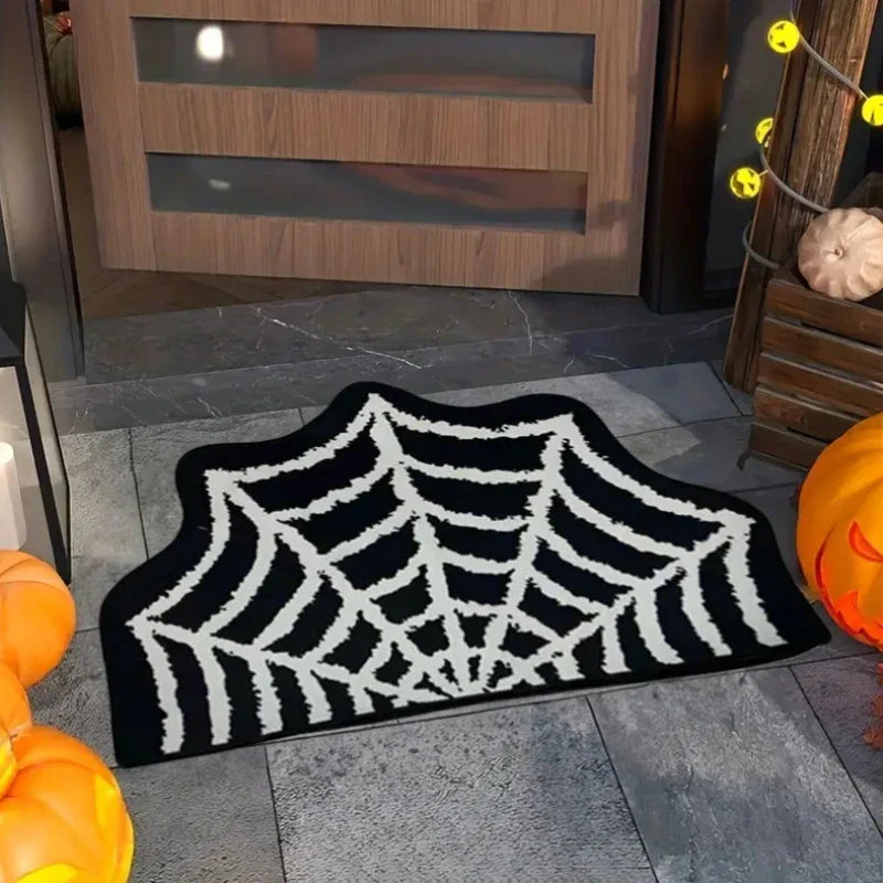 Spider web doormat on a stone floor with pumpkins and Halloween decorations.