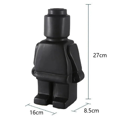 Two Lego Man Vases, one black and one white, designed to look like figures with a decorative plant in each.