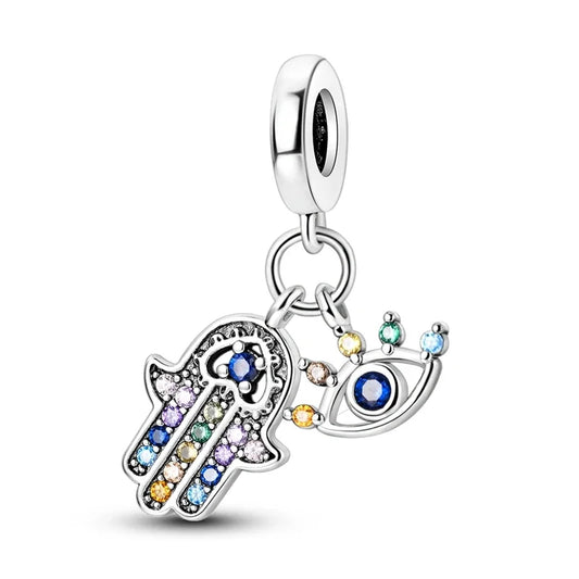 Jewelry charm with hamsa hand and eye design on a white background