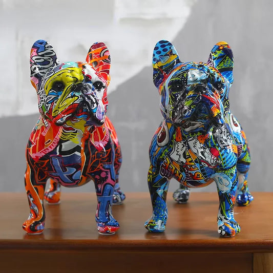 Two colorful dog figurines on a wooden surface with a neutral background, frenchie, french bulldog