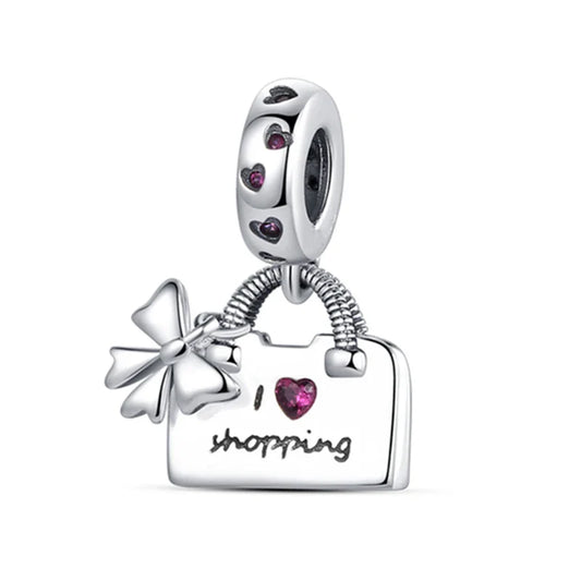 Silver charm with a shopping bag, bow, and heart on a white background